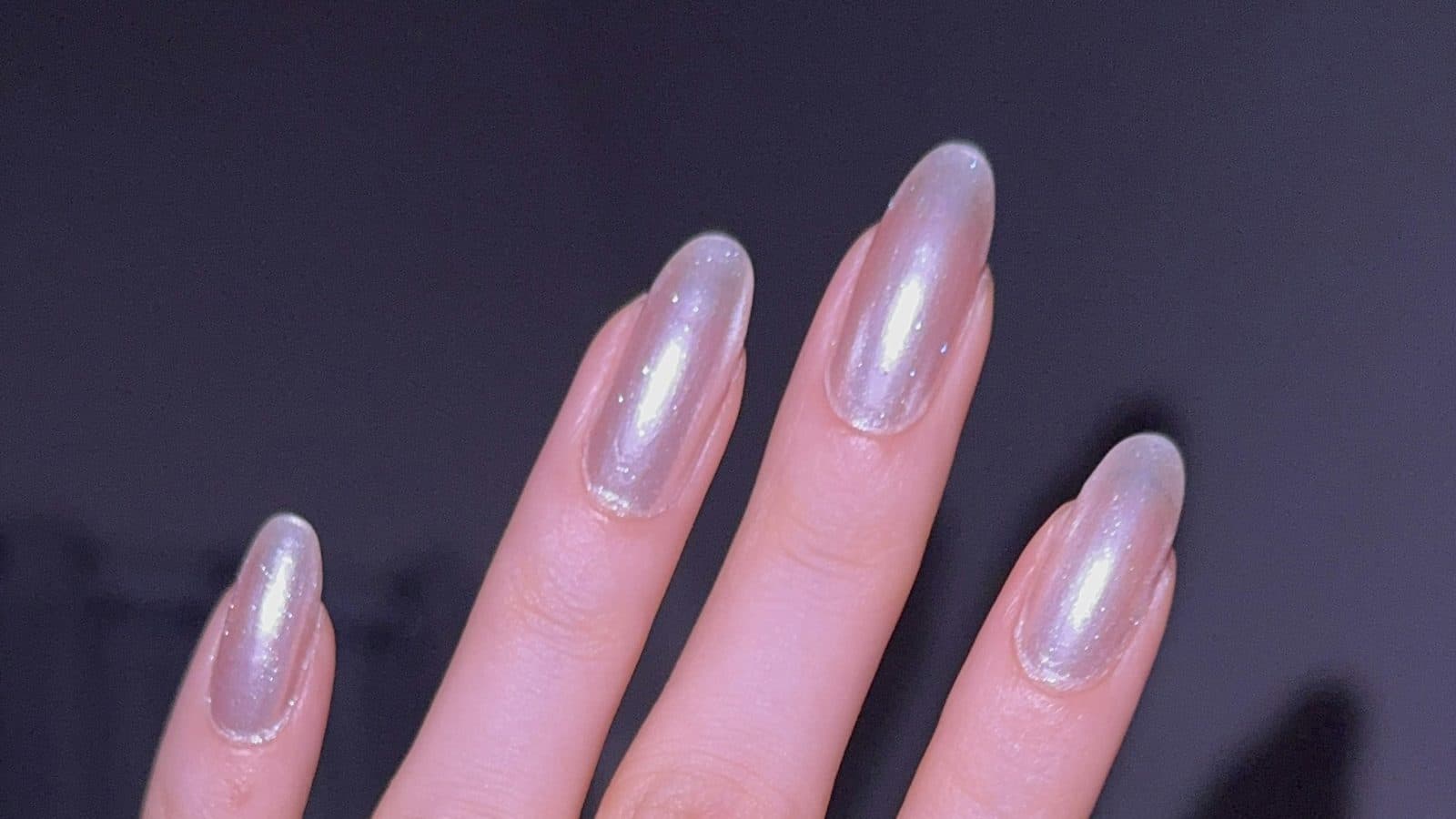 Close-up of almond nails finished with a pearly glazed chrome gel manicure